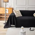 Black waffle weave couch cover with decorative fringe tassels on a modern sofa - 180x150cm / Black