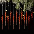 Set de 12 adornos navideños de carámbanos rojos colgados en ramas de pino nevadas - Rojo