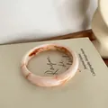 Bracelet jonc minimaliste texture marbre crème et pêche avec design croisé épuré - Style Marbre Artistique / Blanc Rose