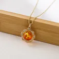 Macro detail of amber flower pendant with gold petals and sparkling crystal border - X793