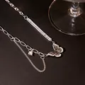 Macro detail of butterfly pendant necklace with shimmering zircons and layered chains - X896-1