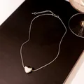 Close-up of silver snake chain necklace featuring a heart pendant with white shell inlay - X896-4