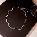 Detailed view of silver fluid-line necklace with clear zircons on black background - Silver Wave Zircon Streamlined Necklace