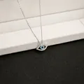 Detailed macro view of silver evil eye pendant with blue crystals on a jewelry stand - X144/3d Glasses
