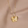 Detailed view of a gold butterfly pendant with opal texture wings on beige satin fabric - Gold Cat's Eye Butterfly Flat Chain