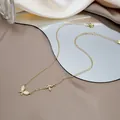 Macro detail of gold layered necklace with opal butterfly pendants and zircon accents - Gold Double Butterfly Cat's Eye Necklace