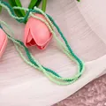 Detailed macro view of 2-4mm faceted green glass beads on layered necklace - Dark and Light Green Multilayer Beaded Necklace