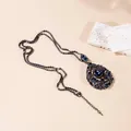 Macro shot of dark gunmetal necklace with teardrop pendant and blue rhinestones - X822