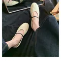 Close-up of beige round toe ballet flats with thin black straps and soft leather texture - EU 35 / Cream