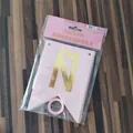 Detail von rosa Papierfahnen mit Goldfolienbuchstaben und Band in der Verpackung - Rosa Goldprägung Spanisch