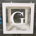 Détail d'une boîte de décoration de fête blanche avec fenêtre transparente et lettre G - Lettre G / Blanc