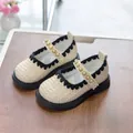 Detail of cream Mary Jane shoe with woven texture, lace trim, and pearl-beaded strap - Size 21 / White