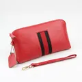 Red pebbled leather wallet featuring iconic black and red striped webbing and wrist strap - Red