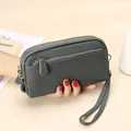 Dark grey leather clutch bag with three zip compartments and a gold-tone wrist strap - Almond Green