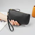 Women's black pebbled leather wristlet wallet with a gold zipper and minimalist design - Black