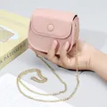 Mini-Umhängetasche aus pinkem genarbtem Leder mit goldener Kette in der Hand gehalten - Hellrosa