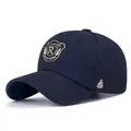 Navy blue baseball cap featuring embroidered shield patch and curved sunshade brim - Adjustable / Navy Blue