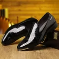 Close-up of black patent leather dress shoes with gold metal trim and star embossing - EU 40 / Black