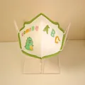 3D KN95 protective mask for kids with cartoon dinosaur pattern and green scalloped edges - Dinosaur