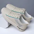 White casual men's sneakers featuring green and blue stripes and breathable perforations - EU 38 / Off White