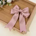 Detailed macro view of pink satin bow hair clip with intricate scalloped lace edges - Deep Pink