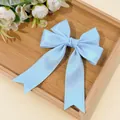 Detail of light blue satin bow hair clip with decorative lace edges on a wooden tray - Dark Blue