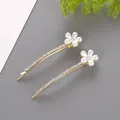 Eleganti fermagli per capelli dorati con fiore di perla e strass su sfondo grigio - Stile Floreale