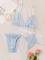 Dettaglio set lingerie in pizzo azzurro su marmo con raffinati accessori decorativi - S / Azzurro