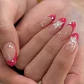 Vista detallada de uñas almendradas con puntas French rosa y patrones de estrellas blancas - Estilo Cielo Estrellado