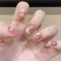 Short nude press-on nails with golden cat-eye glitter and colorful macaron star patterns - Box Packaging