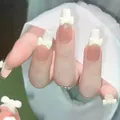 Close-up of nude pink French press-on nails with 3D yellow bows and white tips - Jade Butterfly Yellow Bow Style (BY1040) / Glue Type