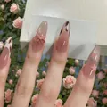 Rosa Mandel-Nagel-Set mit Schleife, Sternen und Katzenaugen-Glitzereffekt auf Blumenhintergrund - Schachtelverpackung / Nude Rosa Leopardenmuster Schleife