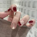 Korte wijnrode kunstnagels met witte stippen en rode 3D-strikjes als accenten - Verpakt Model / Bordeauxrood