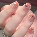 Macro shot of peach gradient press-on nails with heart gemstone and sparkling rhinestones - Yellow Diamond