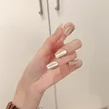 Macro view of long coffin-shaped silver cat-eye magnetic press-on nails on hands - Silver Cat Eye (Liquid Glue)