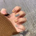 Close-up of milky white French press-on nails with colorful firework hand-painted textures - Fireworks Cat Eye (Liquid Glue)
