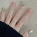 Détail de faux ongles œil de chat vert nude avec paillettes et bague en or rose - Paillettes Œil de Chat Vert (BY1443)