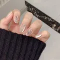 Detail of luxury press-on nails with champagne cat-eye effect and large rhinestone accents - Champagne Gold (Liquid Glue)