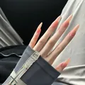 Detail of nude pink translucent stiletto press-on nails worn with silver cross sleeve - Stiletto Nude (BY1463)