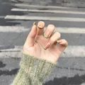 French press-on nails featuring green plaid tips and nude base on model's hand - Green Plaid French