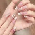 Details von rosa French-Nägeln mit 3D-Schleifen, Perlen und Herzverzierungen - Langer Sarg / Box-Stil