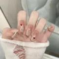 Detailansicht der handgemachten Press-On Nails mit Katzenaugen-Strass und Herz-Designs - Verpackt