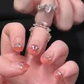 Ring mit rosa Herz-Edelstein und Farbverlauf-Nagelstickern mit Schleife und Strasssteinen - Bernstein-Kristall-Punkt-Stil (BY1129)