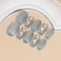 Dettaglio di unghie finte grigie cat-eye con strass 3D su specchio dorato - Aurora Blu (BY1318) / Stile Colla per Fototerapia