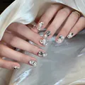 Detail van handgemaakte luxe kunstnagels met parels en fonkelende steentjes op satijn - Fototherapie Lijm Stijl / 24 Stuks/Set / Parelmoerachtig en Glanzend (BY1364)