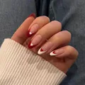 Almond-shaped press-on nails with red and white French design and heart accents - Phototherapy Glue Style