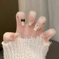 Dettaglio di unghie finte con glitter argento, fiocco 3D nero e piccoli accenti di perle - Tipo standard / Stile Grazioso (BY1994)