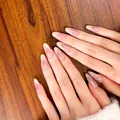 Gros plan d'ongles longs en amande avec dégradé French rose et blanc sur fond de bois - 30 Pièces/Planche (Taille Complète) / Nude frais et décontracté (BS2107)