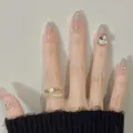 Dettaglio anello doppio dorato con motivi a vite e strass incastonati sulla mano - Stile in Scatola (BY1636)