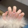Detail of French cat eye press-on nails with 3D red bows and silver chain accents - M / Handmade Bagged